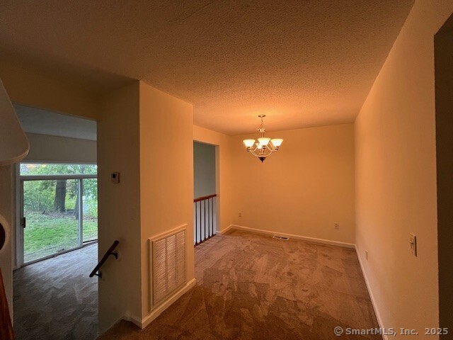 346 Prospect Ave Unit 3, New Haven, CT 06512 - empty room featuring carpet, a chandelier, a textured ceiling, and baseboards