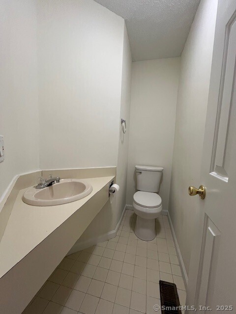 346 Prospect Ave Unit 3, New Haven, CT 06512 - bathroom featuring a sink, tile patterned flooring, toilet, a textured ceiling, and baseboards