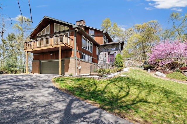 81 Georges Ln, Monroe, CT 06468 - view of property exterior featuring a chimney, a garage, driveway, a lawn, and brick siding