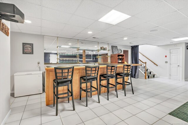 81 Georges Ln, Monroe, CT 06468 - indoor wet bar featuring fridge, stairs, baseboards, a drop ceiling, and light tile patterned floors