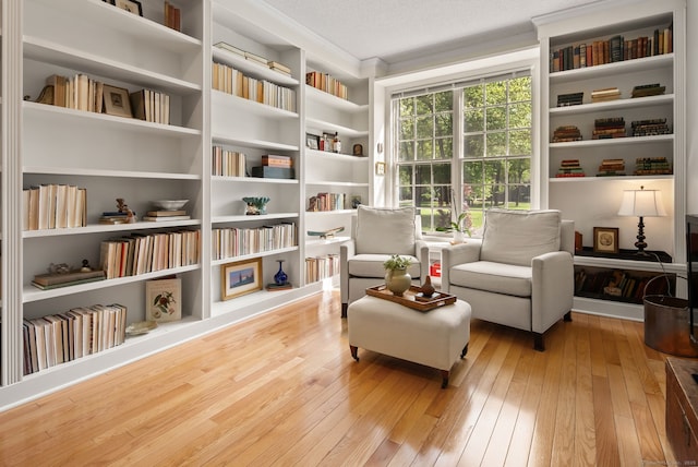 5 Harwich Ln Unit 5, West Hartford, CT 06117 - sitting room with wood-type flooring, wall of books, crown molding, and built in features