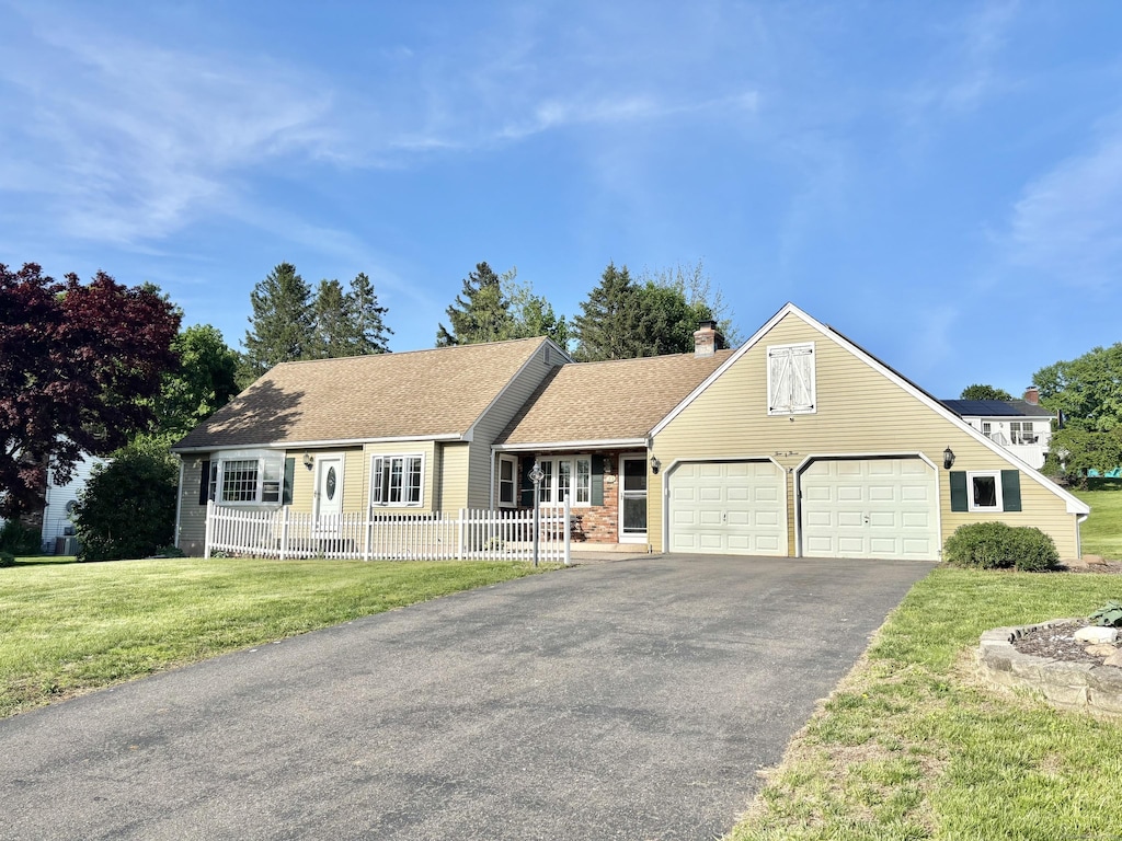 23 Strawberry Ln, Manchester, CT 06040 - view of front of house featuring a garage, driveway, and a chimney