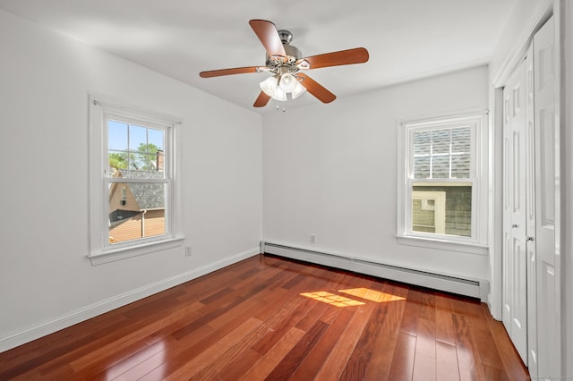 29 E Cliff St, Norwich, CT 06360 - unfurnished bedroom with baseboard heating, dark wood finished floors, a closet, ceiling fan, and baseboards
