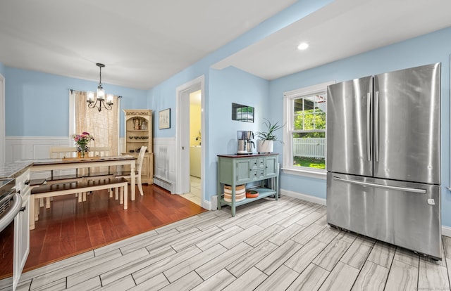 29 E Cliff St, Norwich, CT 06360 - kitchen with freestanding refrigerator, a chandelier, wood finish floors, wainscoting, and range