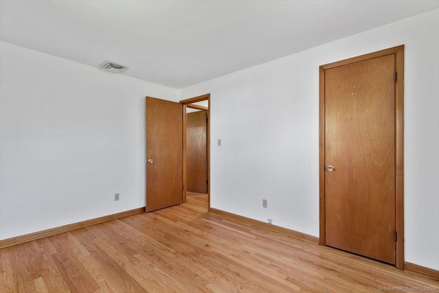 empty room featuring light wood-style floors and baseboards