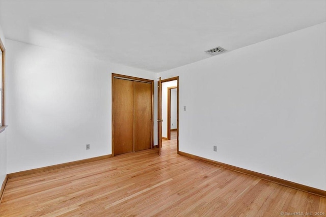 spare room featuring light wood-type flooring and baseboards