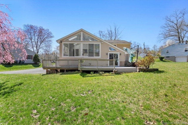 rear view of house with a wooden deck and a yard