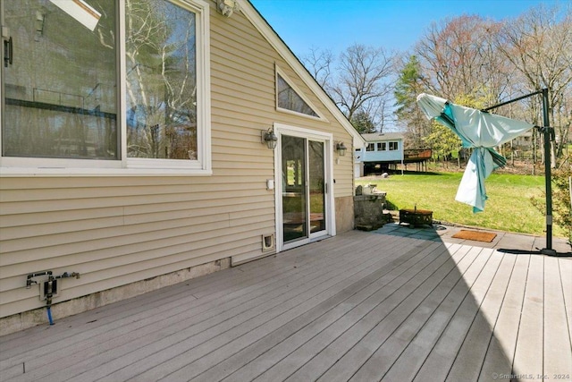 wooden deck featuring a lawn