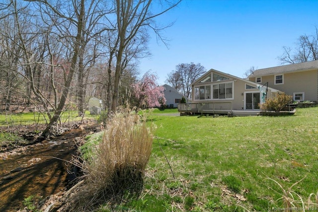 view of green lawn with a sunroom