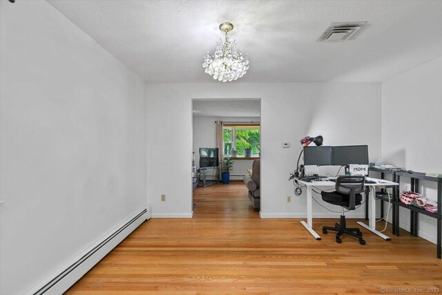 26 Jodi Dr, Wallingford, CT 06492 - office space with a baseboard heating unit, light wood-style floors, a chandelier, baseboards, and a textured ceiling