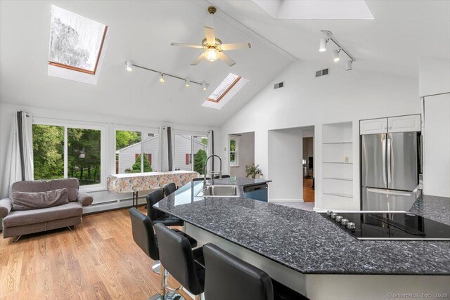 26 Jodi Dr, Wallingford, CT 06492 - kitchen with freestanding refrigerator, track lighting, a skylight, a sink, and black electric stovetop