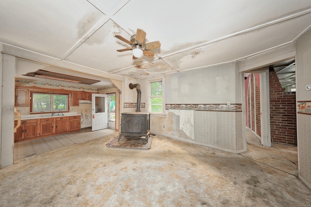 50 Hill Top Rd, Morris, CT 06763 - unfurnished living room featuring a wood stove, a ceiling fan, and a sink