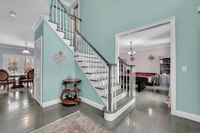 staircase featuring ornamental molding, wood finished floors, baseboards, and a chandelier