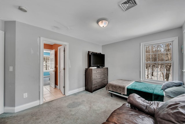 bedroom with carpet flooring, baseboards, and ensuite bath
