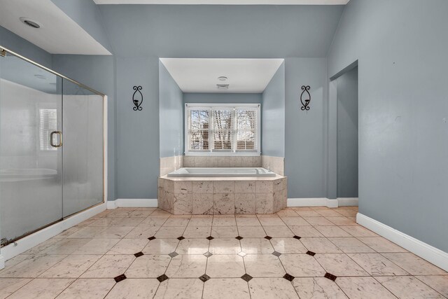 full bathroom featuring a garden tub, a shower stall, baseboards, and tile patterned flooring