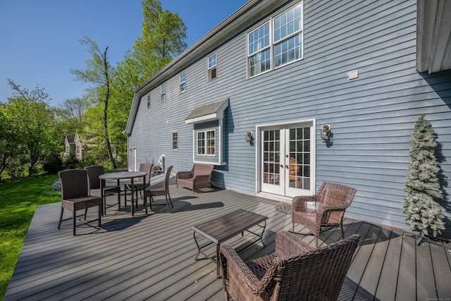 wooden terrace with french doors, outdoor lounge area, and outdoor dining area