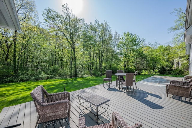 wooden terrace with a lawn and outdoor dining space