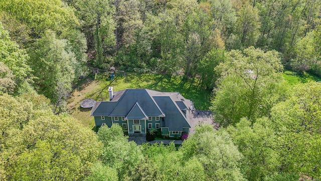 aerial view of property and surrounding area featuring a forest
