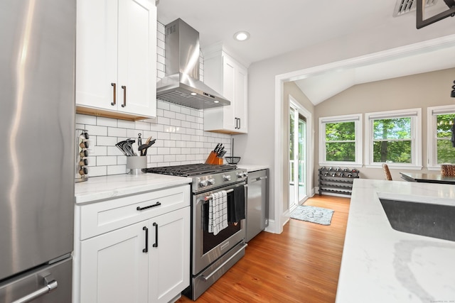 48 Sprucedale Dr, Waterbury, CT 06706 - kitchen with stainless steel appliances, wall chimney range hood, lofted ceiling, backsplash, and light wood-type flooring