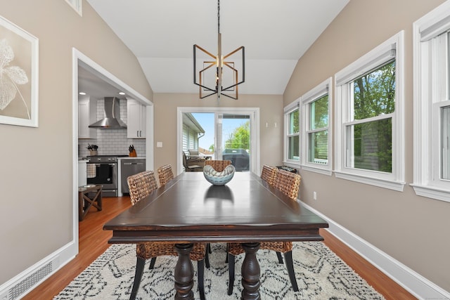 48 Sprucedale Dr, Waterbury, CT 06706 - dining space featuring lofted ceiling, wood finished floors, a chandelier, and baseboards