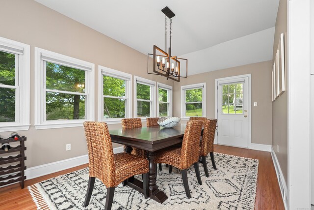 48 Sprucedale Dr, Waterbury, CT 06706 - dining space with a chandelier, wood finished floors, baseboards, and lofted ceiling