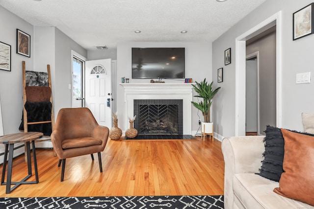 48 Sprucedale Dr, Waterbury, CT 06706 - living room featuring wood finished floors, a fireplace, a textured ceiling, and recessed lighting