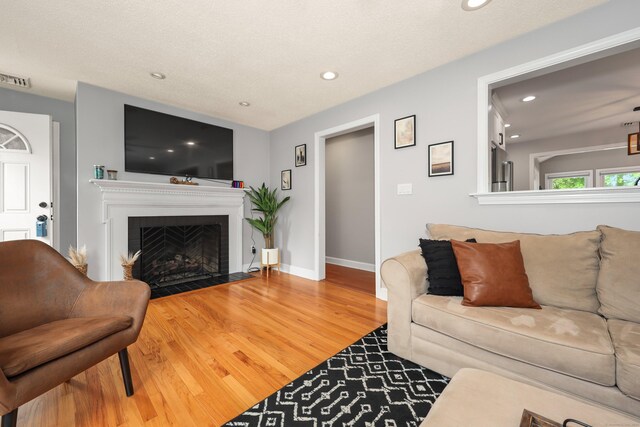 48 Sprucedale Dr, Waterbury, CT 06706 - living room with wood finished floors, recessed lighting, a fireplace with flush hearth, and baseboards