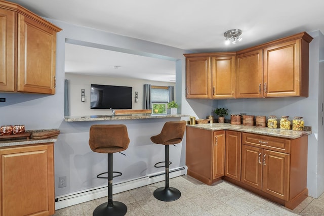 387 New London Tpke, Stonington, CT 06378 - kitchen featuring a baseboard radiator, a breakfast bar, brown cabinets, and light stone countertops