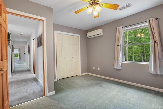 387 New London Tpke, Stonington, CT 06378 - unfurnished bedroom with a wall mounted AC, carpet flooring, baseboards, a closet, and ceiling fan