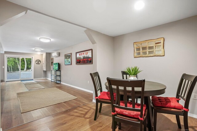 387 New London Tpke, Stonington, CT 06378 - dining space featuring a wall mounted air conditioner, wood finished floors, and baseboards