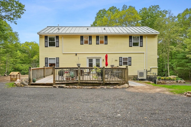387 New London Tpke, Stonington, CT 06378 - rear view of house featuring a standing seam roof, a wooden deck, metal roof, and a cooling unit