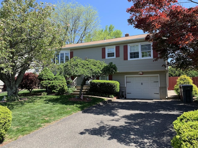 view of front of home with a garage, driveway, and a chimney