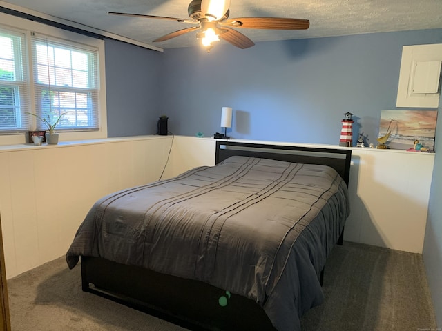carpeted bedroom with ceiling fan and a textured ceiling