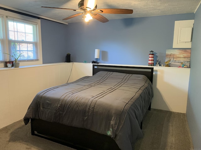 carpeted bedroom with a ceiling fan and a textured ceiling