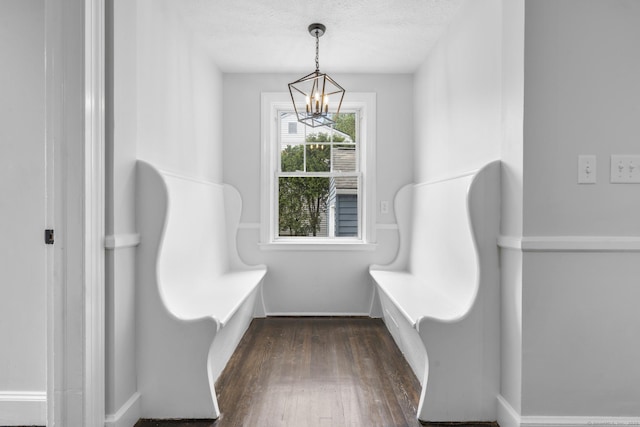 mudroom featuring a chandelier, dark wood-type flooring, and a textured ceiling
