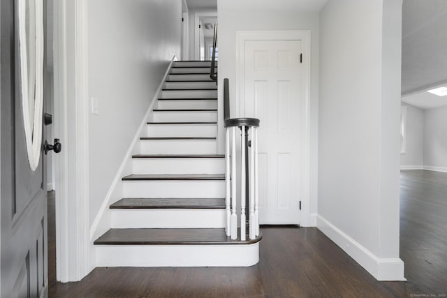 stairway featuring wood finished floors and baseboards