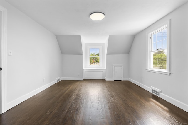 bonus room featuring dark wood finished floors, vaulted ceiling, and baseboards
