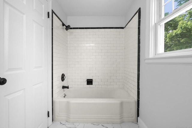 bathroom featuring marble finish flooring and  shower combination
