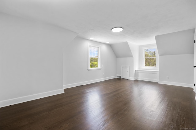 bonus room featuring lofted ceiling, dark wood-type flooring, and baseboards