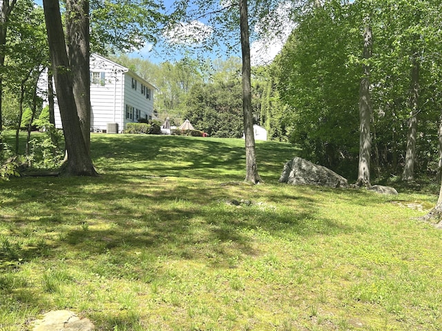 view of green lawn with central air condition unit