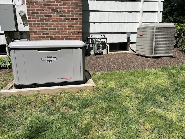 exterior view of a power unit, central air condition unit, gas meter, brick siding, and electric meter
