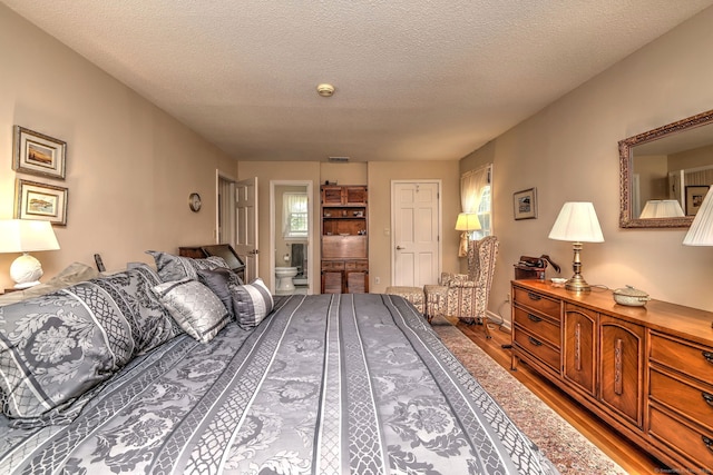 481 Clearbrook Rd, Orange, CT 06477 - bedroom featuring wood finished floors, ensuite bathroom, and a textured ceiling