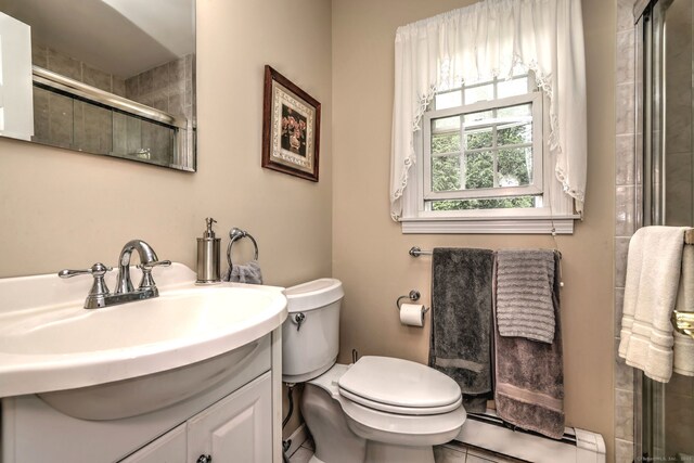 481 Clearbrook Rd, Orange, CT 06477 - bathroom with a baseboard heating unit, vanity, toilet, tiled shower, and tile patterned floors