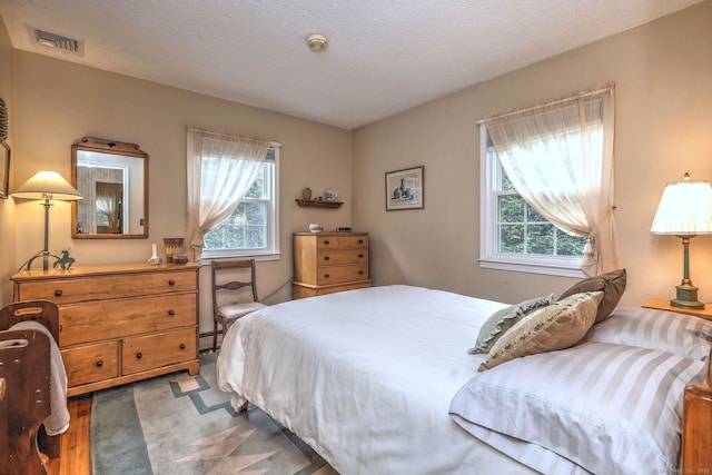 481 Clearbrook Rd, Orange, CT 06477 - bedroom featuring multiple windows, a baseboard heating unit, and a textured ceiling