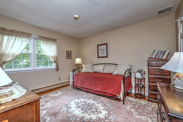 481 Clearbrook Rd, Orange, CT 06477 - bedroom featuring a baseboard heating unit, wood finished floors, baseboards, and a textured ceiling