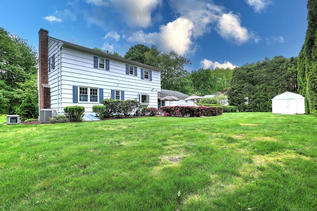 481 Clearbrook Rd, Orange, CT 06477 - back of house with a chimney, central AC, and a yard