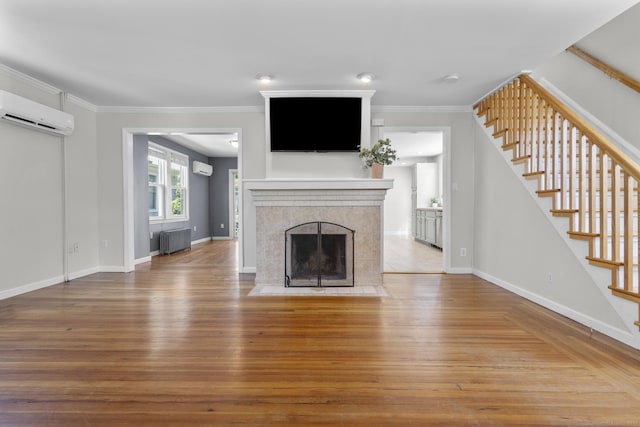 43 Atwater St, Milford, CT 06460 - unfurnished living room featuring radiator heating unit, a wall mounted AC, hardwood / wood-style floors, stairway, and a fireplace