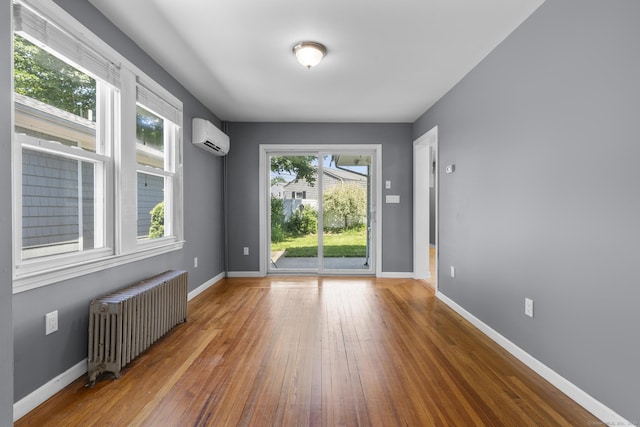 43 Atwater St, Milford, CT 06460 - spare room with radiator, a wall mounted air conditioner, and wood-type flooring
