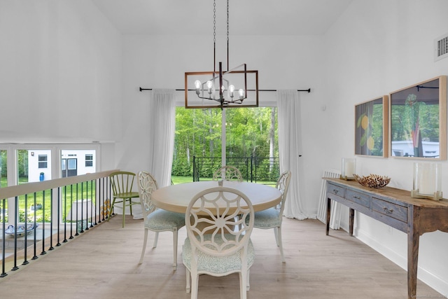 135 Gary Rd, Stamford, CT 06903 - dining room with a chandelier, wood finished floors, a towering ceiling, and baseboards