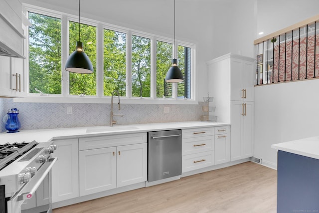 135 Gary Rd, Stamford, CT 06903 - kitchen featuring stainless steel appliances, a sink, backsplash, light countertops, and white cabinets